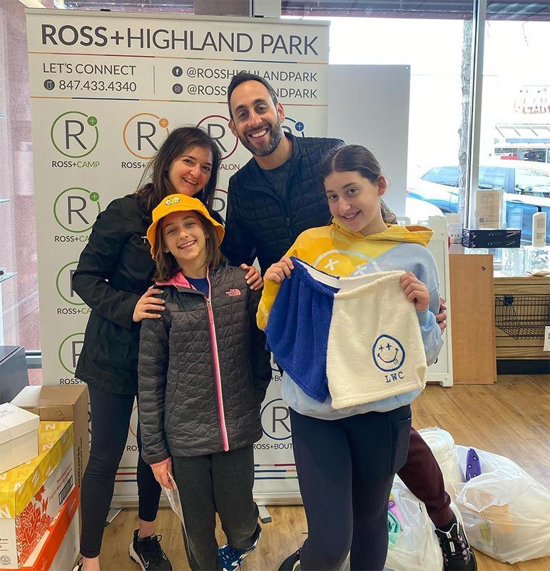 a group of people standing in front of a sign that says ross + highland park