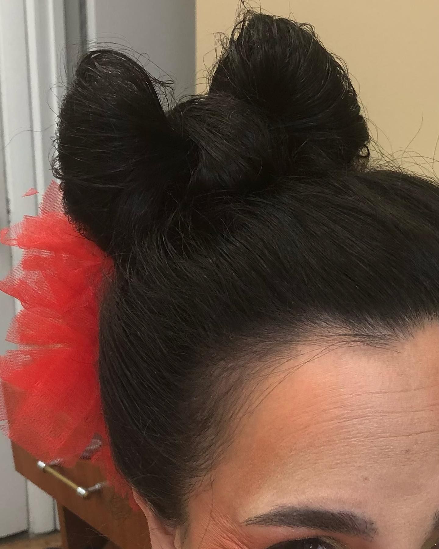 a close up of a woman 's hair with a red bow in it