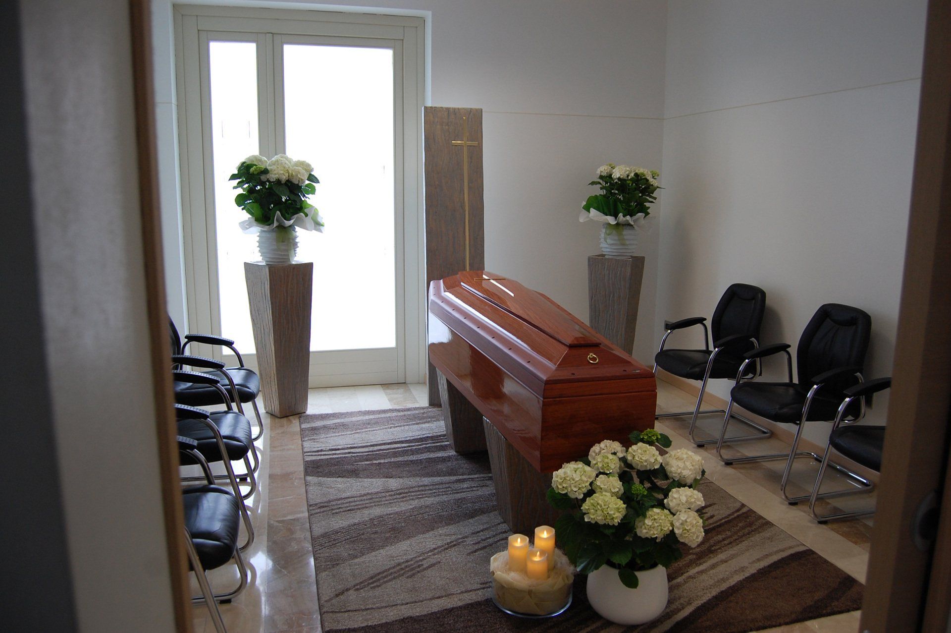 spazio dedicato al defunto con bara, fiori e sedie