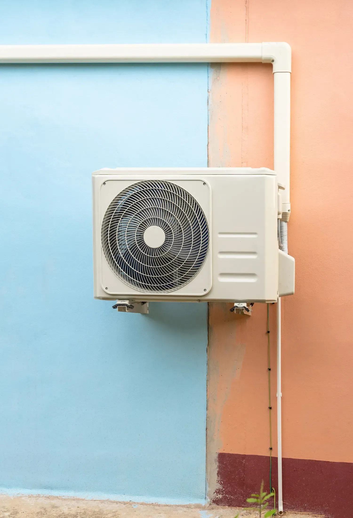 An air conditioner is mounted on the side of a building.