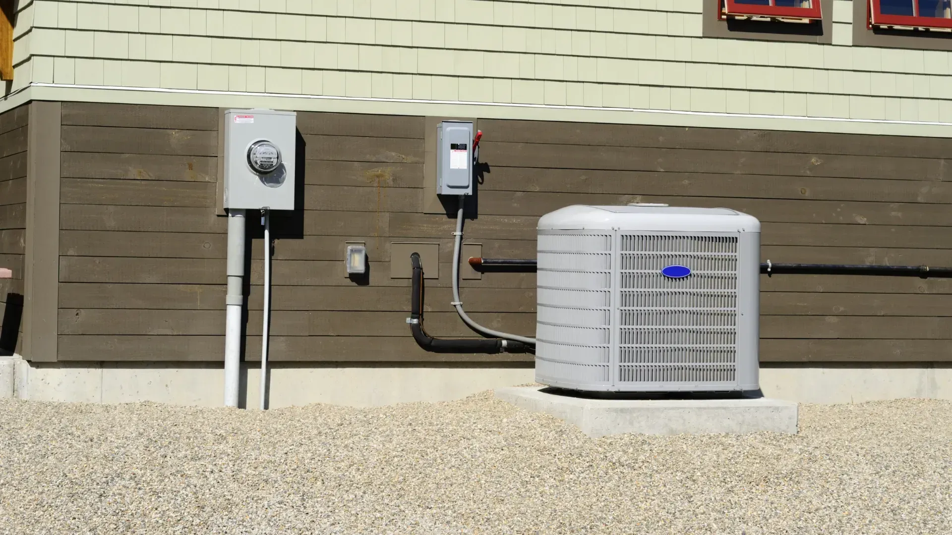 A carrier air conditioner is attached to the side of a house