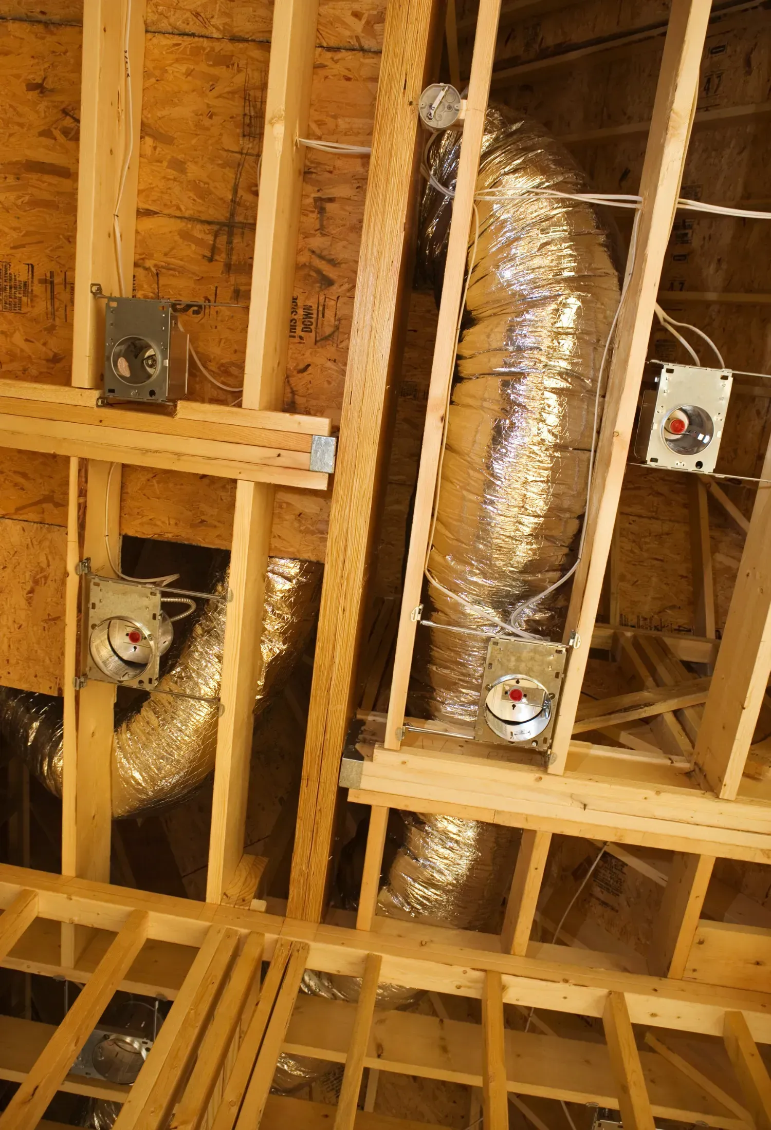 A ceiling with a lot of pipes coming out of it.