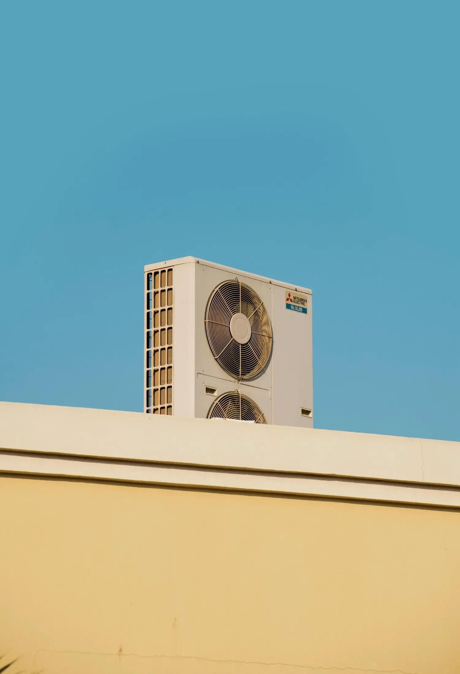 A large air conditioner is mounted on the side of a building.