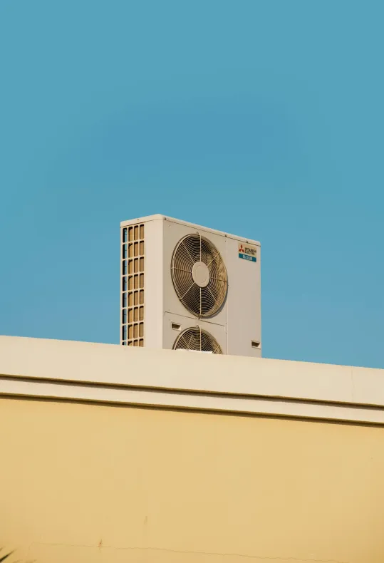 A large air conditioner is mounted on the side of a building.