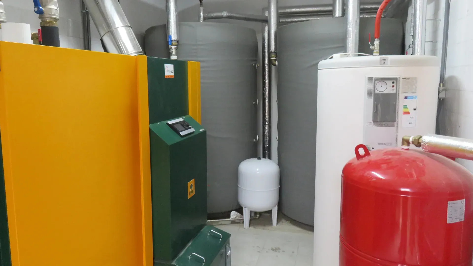 A room with a lot of boilers and tanks in it.