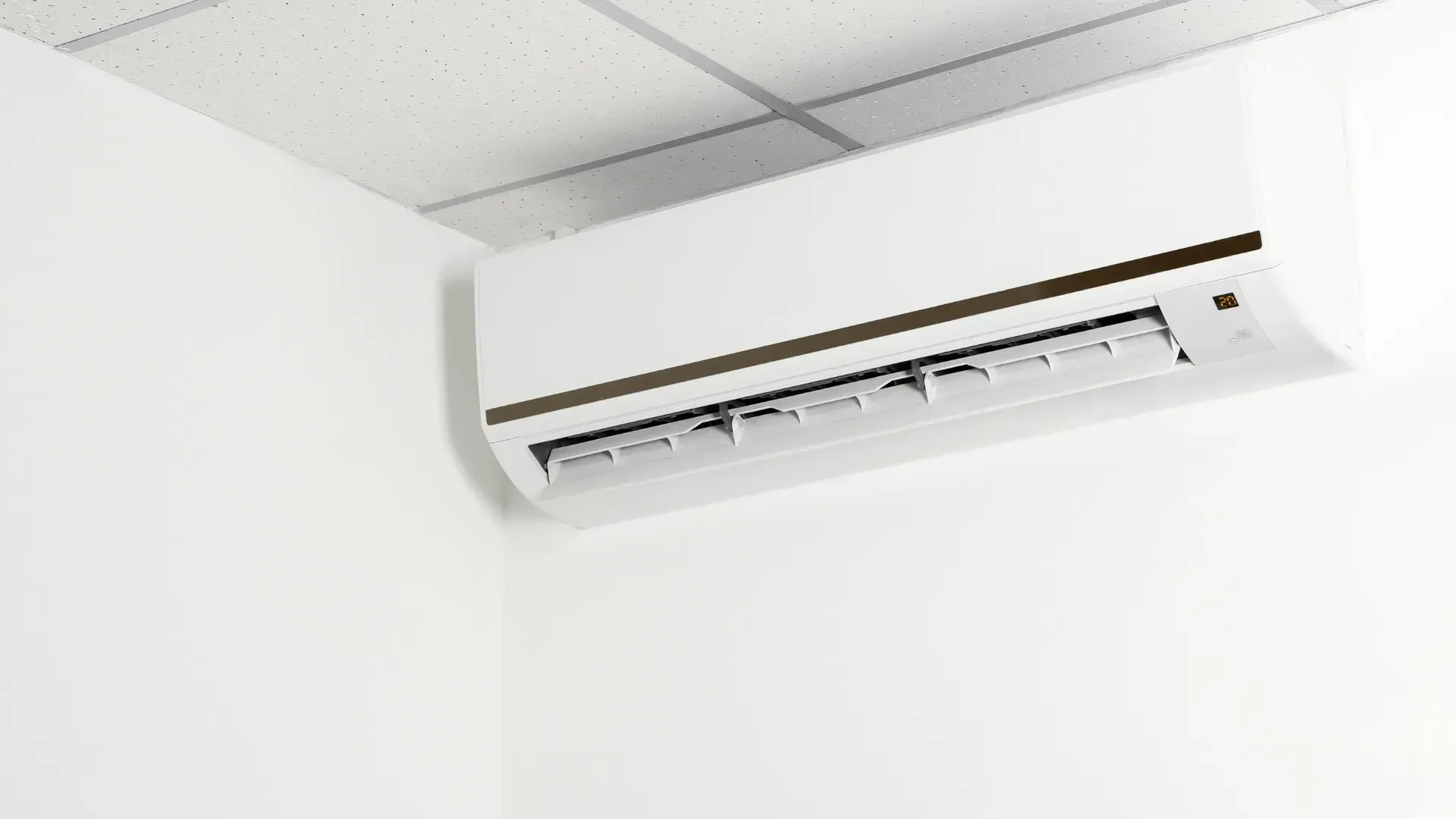 A white air conditioner is hanging from the ceiling in a room.