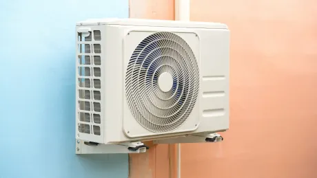 A white air conditioner is mounted on a wall.