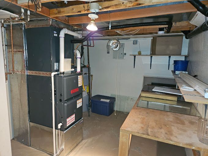 A basement with a furnace and a table in it