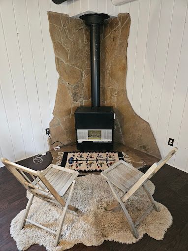 Two chairs are sitting in front of a fireplace in a room.