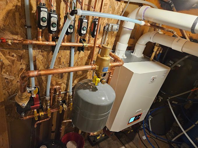 A boiler is being installed in a basement with copper pipes.