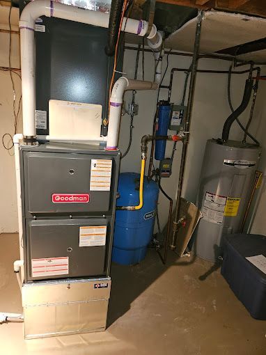 A basement with a heating and cooling system and a water heater.