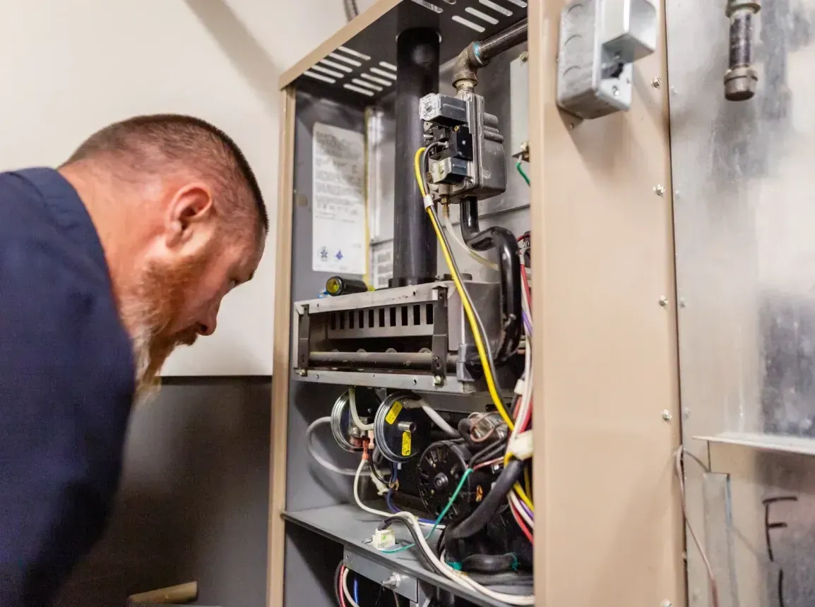 A man is working on a heating system in a home.