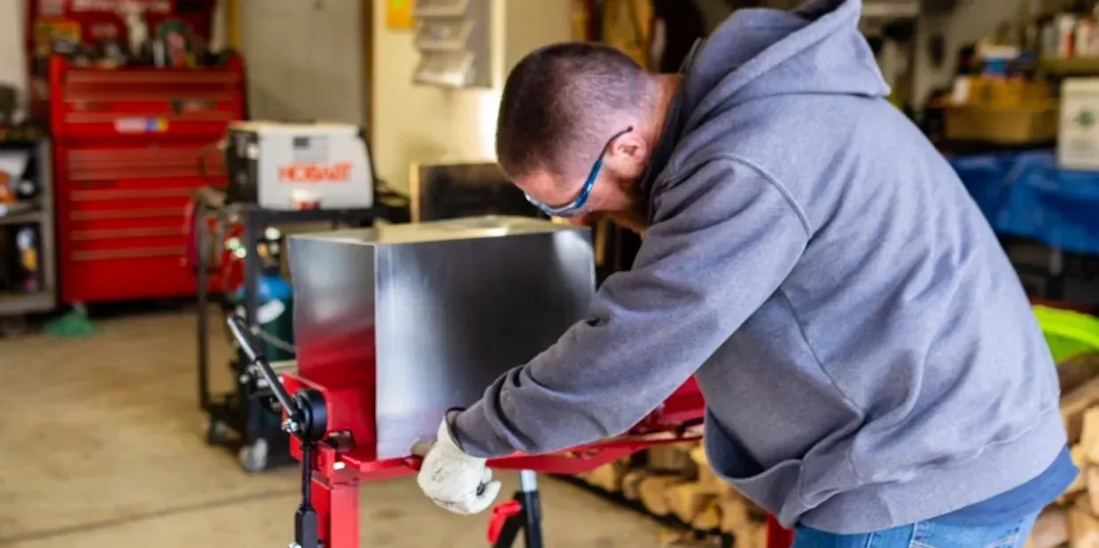 A man is working on a machine in a garage.