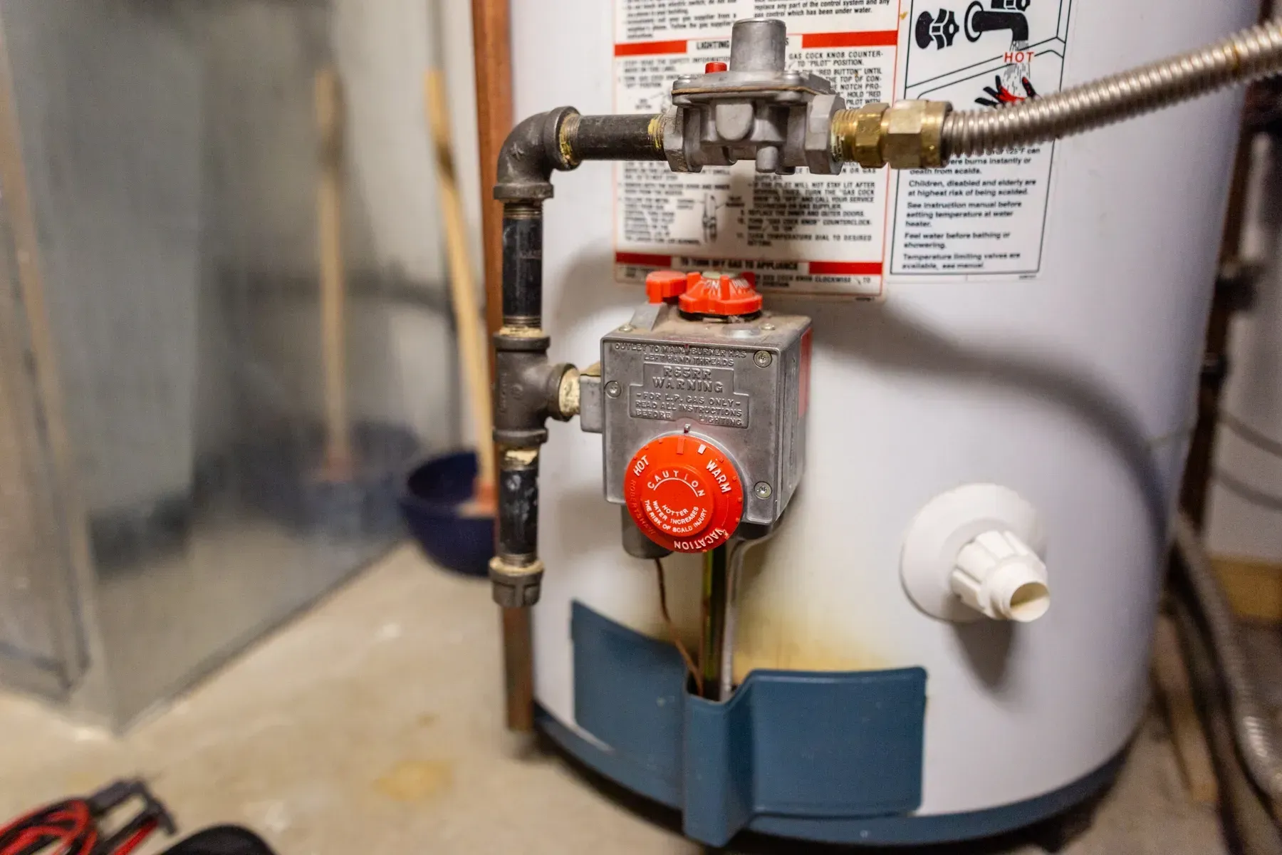 A close up of a water heater in a basement.