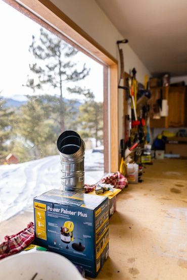 A box of a vacuum cleaner is sitting on a wooden table in a garage.