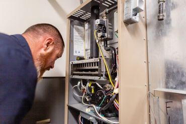 A man is working on a heating system in a home.