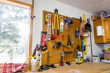 A workbench with lots of tools hanging on the wall.