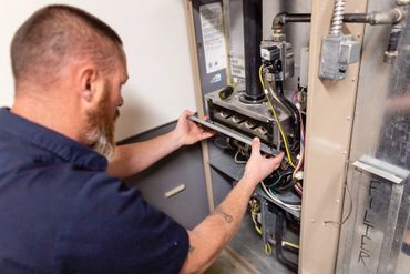 A man is working on a heating system in a house.