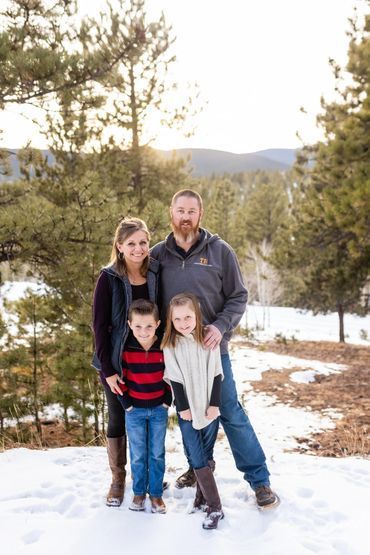 A family is posing for a picture in the snow.