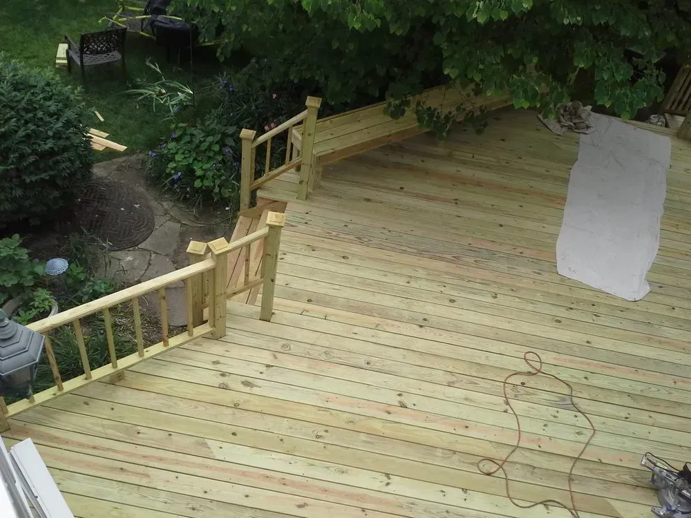 An aerial view of a wooden deck with stairs and a bench.