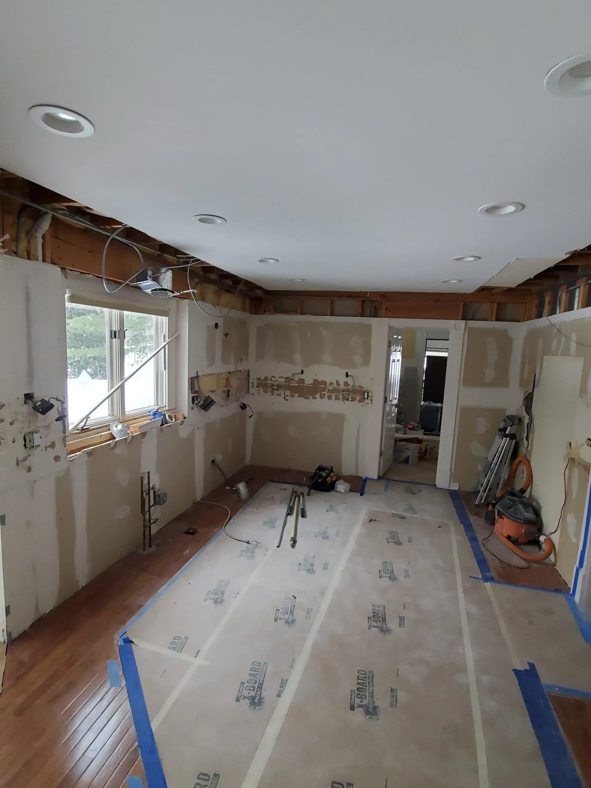 A room that is being remodeled with a lot of tape on the floor.