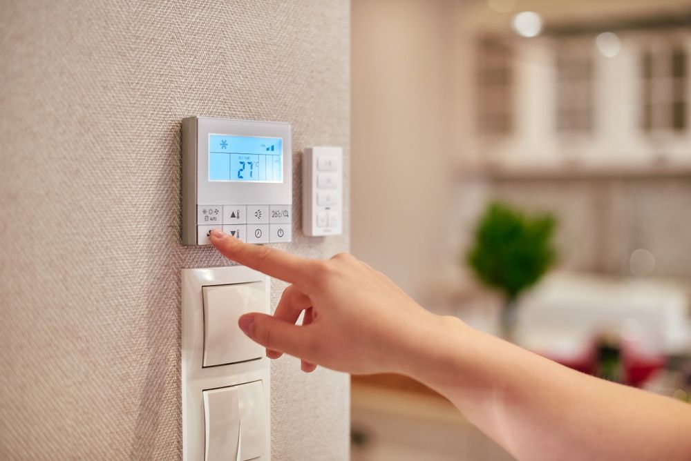A Person is Pressing a Button on a Thermostat — Airac Sales & Service in Berserker, QLD