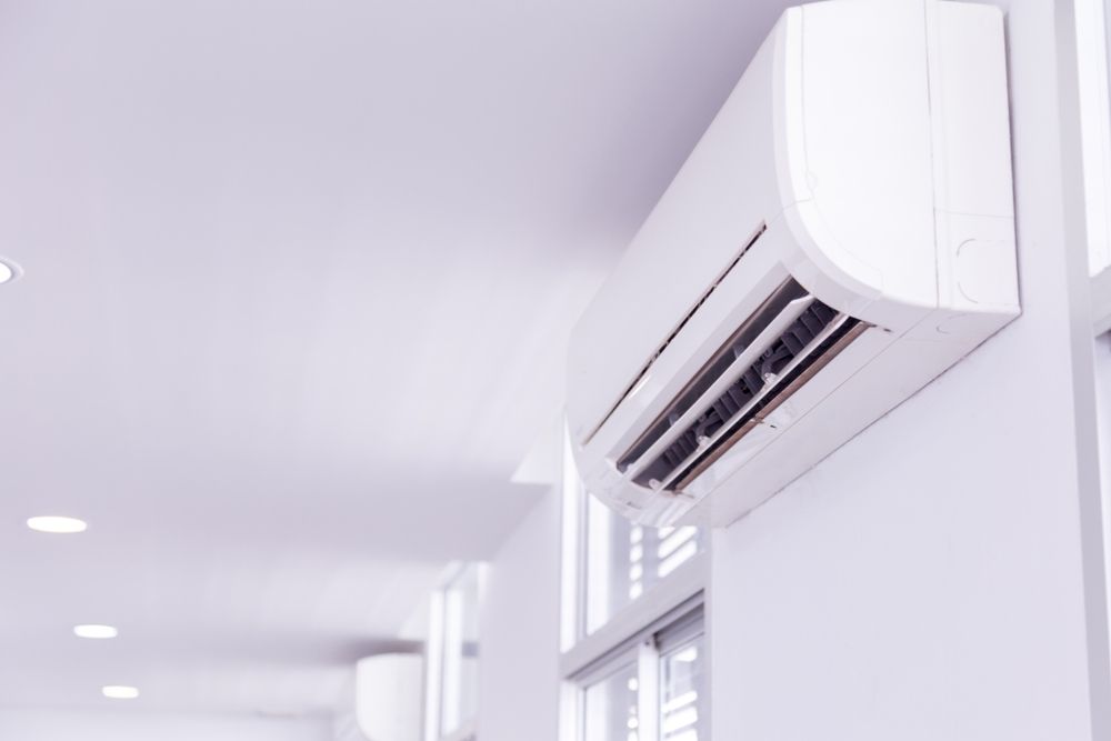 A White Air Conditioner is Hanging on a White Wall in a Hallway