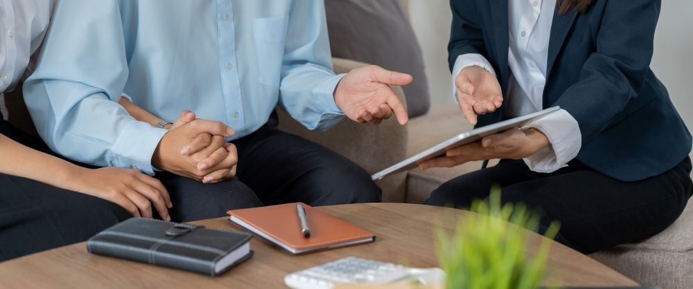 A Man and a Woman Are Sitting at a Table With a Tablet — Airac Sales & Service in Berserker, QLD