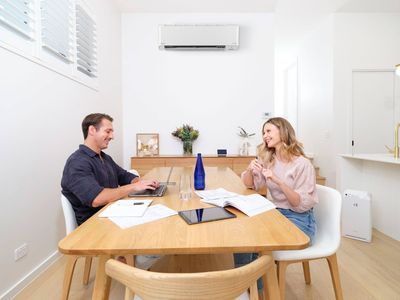 A Man and a Woman Are Sitting at a Table in a Dining Room — Airac Sales & Service in Berserker, QLD