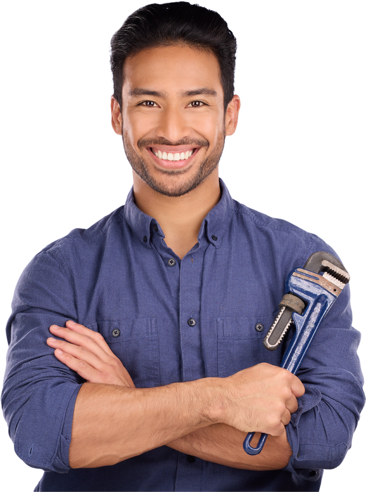 A man in a blue shirt is holding a wrench and smiling.