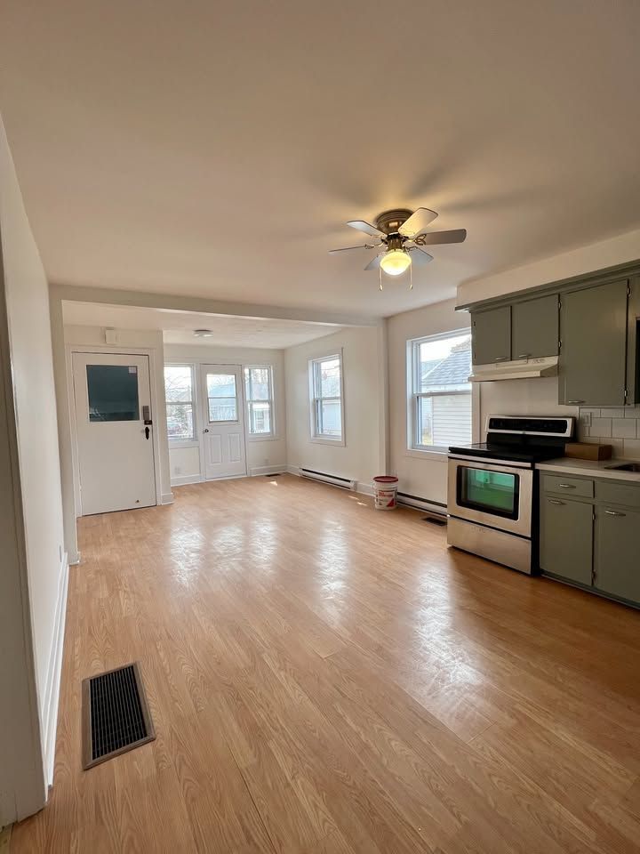 There is a ceiling fan in the living room and a kitchen.
