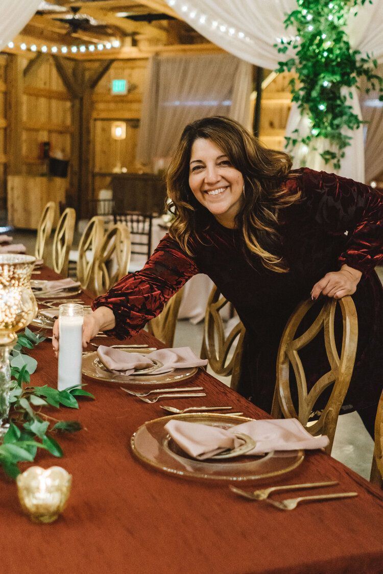 A Woman Is Standing Next to a Table Set for a Wedding Reception by Wedding Planner Nashville