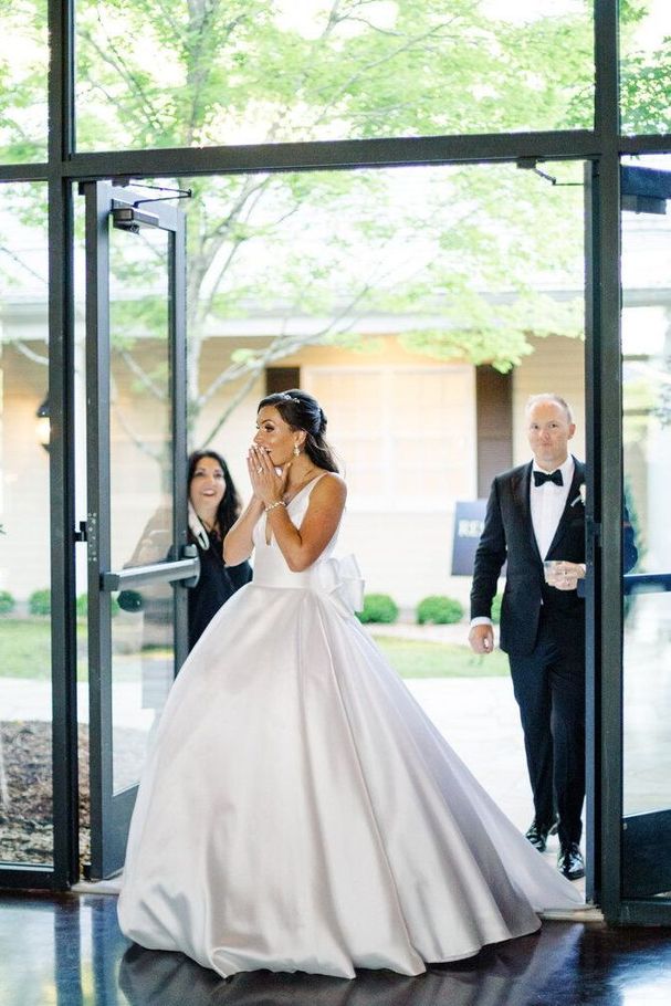 A Bride in a Wedding Dress Is Walking Down the Aisle with Her Groom by Wedding Planner Nashville