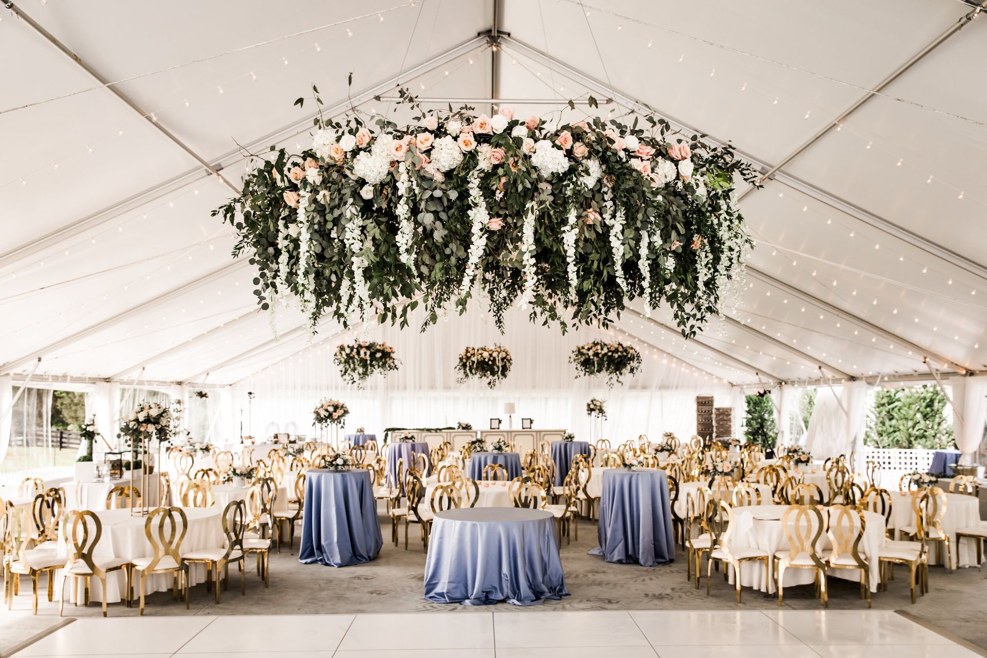 Weeding reception tables and chairs and flowers hanging from the ceiling by Wedding Planner Nashville