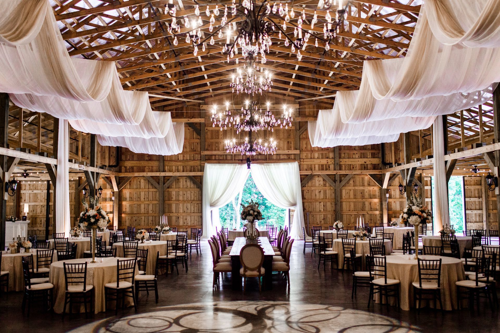 Julie and Zach's Wedding barn filled with tables and chairs and a dance floor by Wedding Planner Nashville