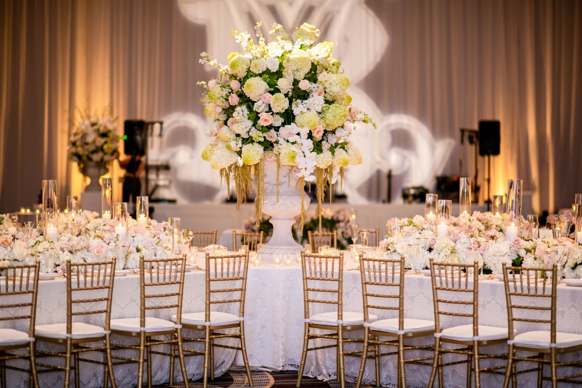 Mary Catherine and Blake’s Wedding  reception with tables and chairs and a large vase of flowers on the table by Wedding Planner Nashville