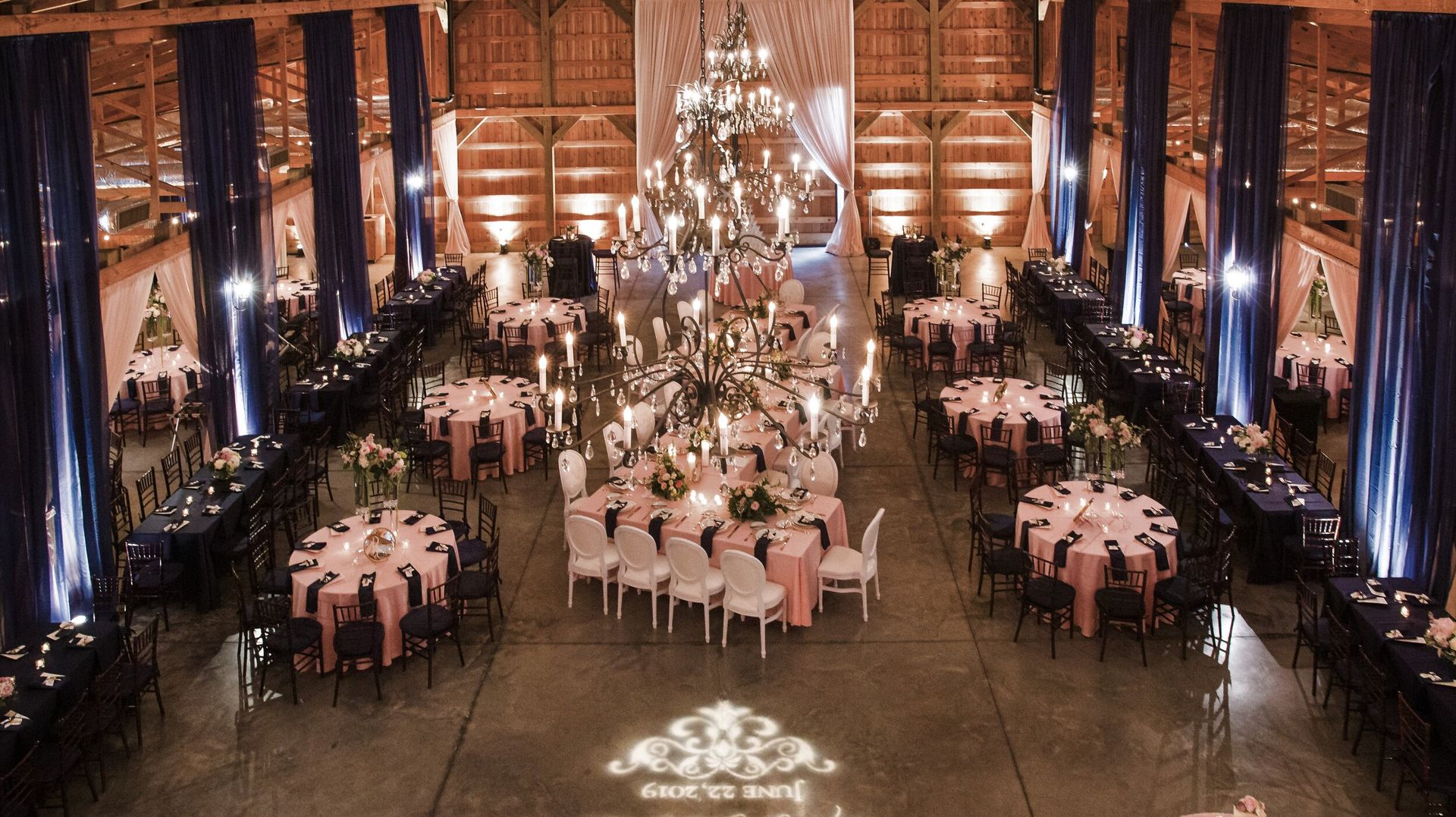 Rachel & Andrew's Wedding room filled with tables and chairs and a chandelier by Wedding Planner Nashville