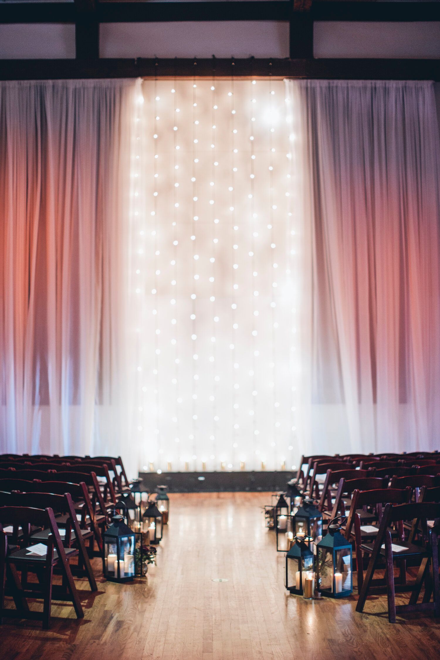 Rachel & Rick's Wedding row of chairs are lined up in front of a wall of lights by Wedding Planner Nashville