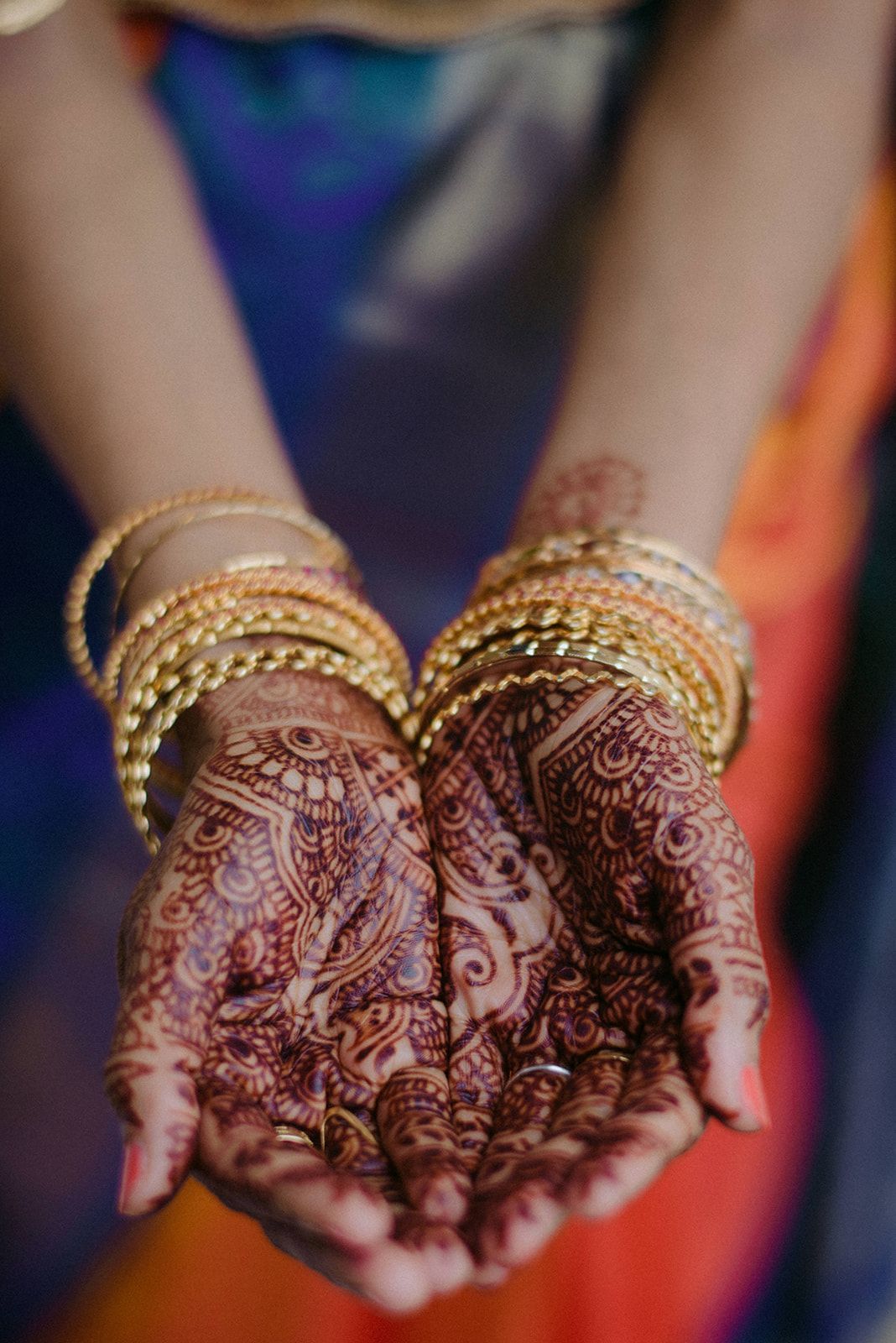 Birde with henna on her hands is holding a pair of wedding rings by Wedding Planner Nashville