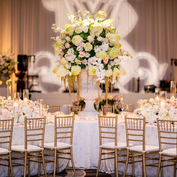 A Woman Is Standing Next to a Table Set for a Wedding Reception by Wedding Planner Nashville