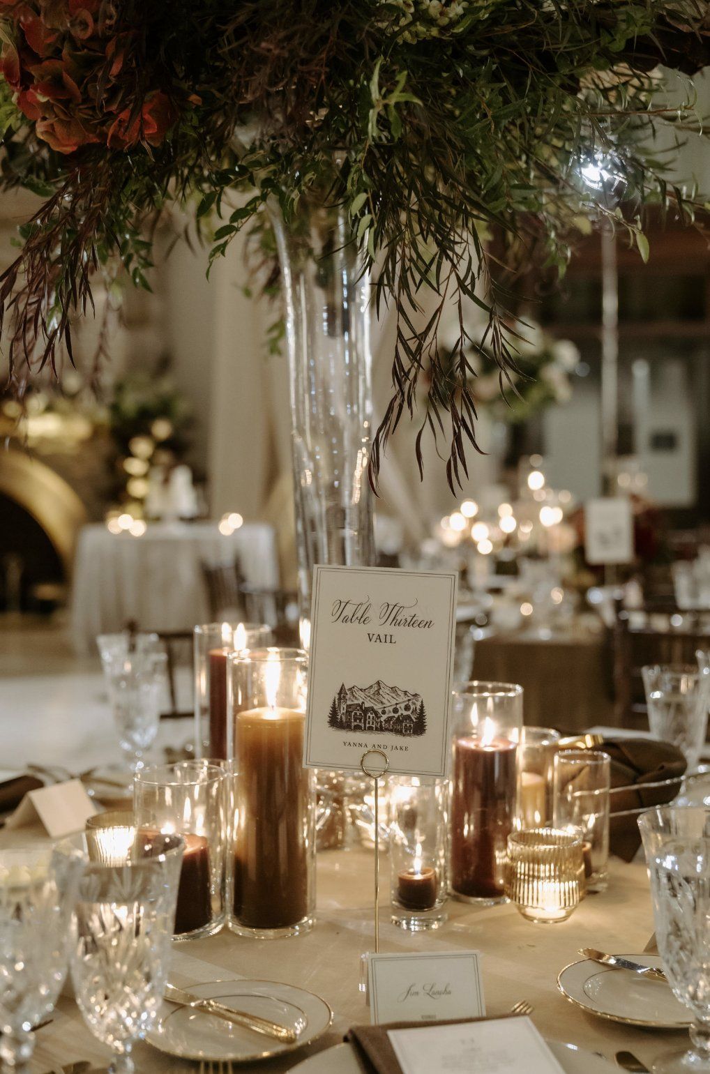 Centerpiece with flowers and candles on a decorated table at a wedding reception by Luxury Wedding Planners in Nashville, TN