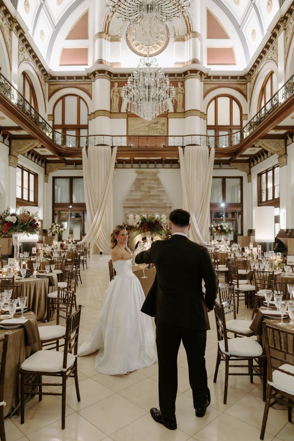 Bride and groom at wedding reception, bride in white gown, groom in black suit, ornate building by Luxury Wedding Planners in Nashville, TN