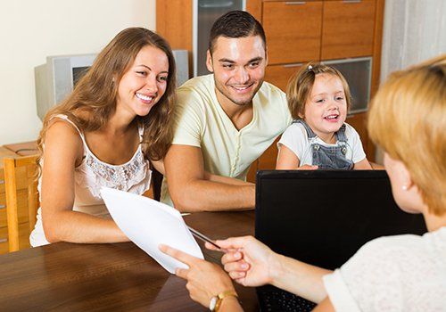 Berater zeigt einer Familie während einer Beratung ein Dokument