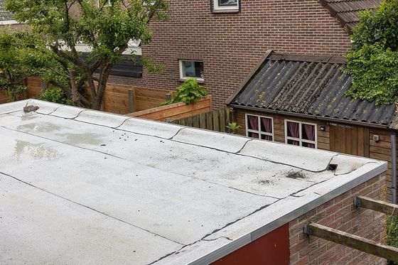 a view of a roof with a house in the background