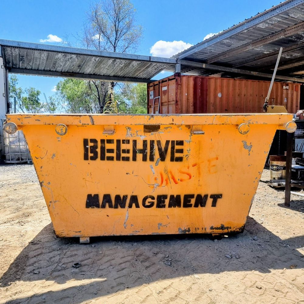 A Woman in a Pink Shirt and Blue Skirt is Raking Dirt — Beehive Property Maintenance in Gemfields, QLD