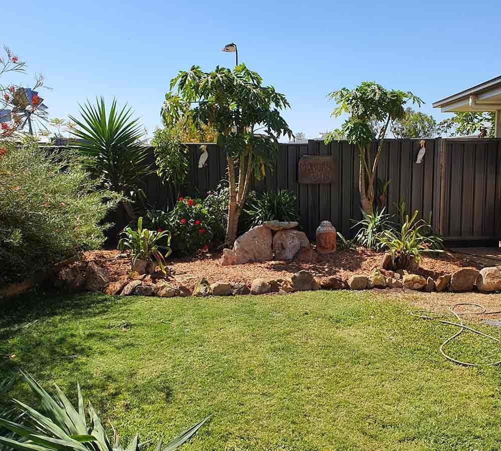 A Path in a Garden With Flowers and a Bridge — Beehive Property Maintenance in Capella, QLD