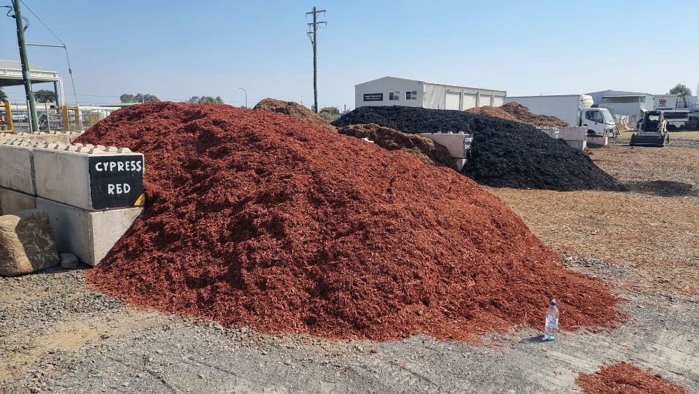 A Stone Wall Surrounded by Flowers and Plants in a Garden — Beehive Property Maintenance in Moranbah, QLD