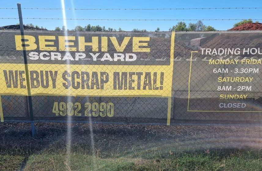 A Man is Cutting a Hedge With a Lawn Mower — Beehive Property Maintenance in Comet, QLD