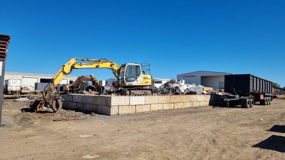 A Stone Wall Surrounded by Flowers in a Garden — Beehive Property Maintenance in Gemfields, QLD