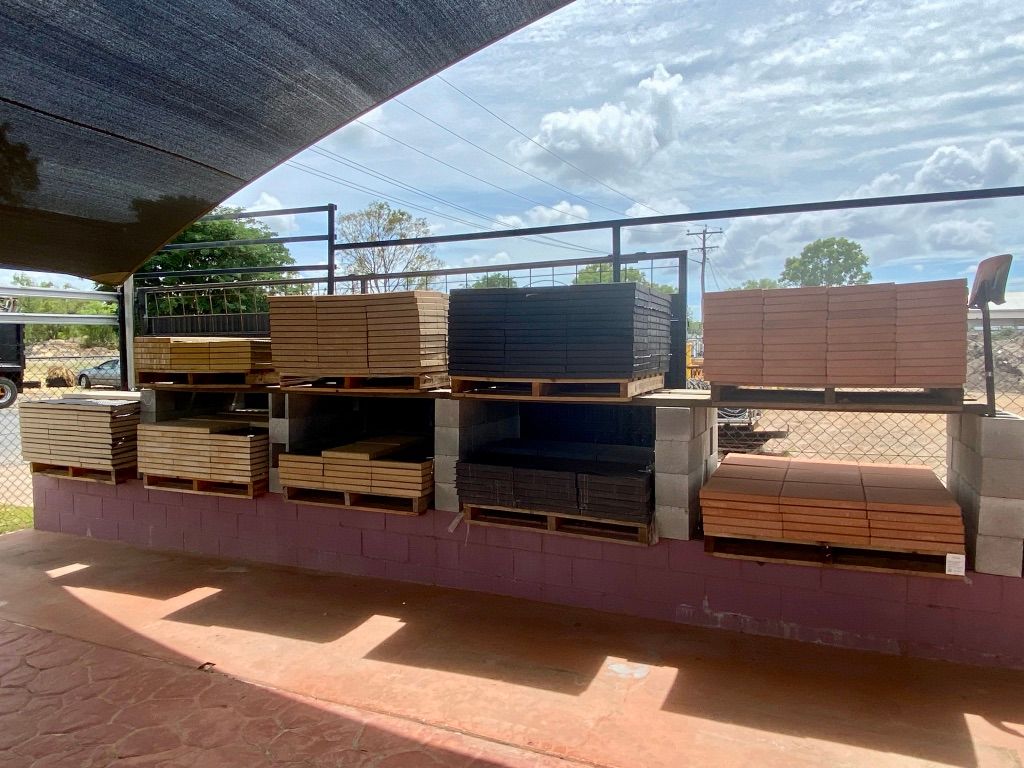 A Bunch Of Wooden Pallets Sitting On Top Of A Brick Wall — Beehive Property Maintenance in Emerald, QLD